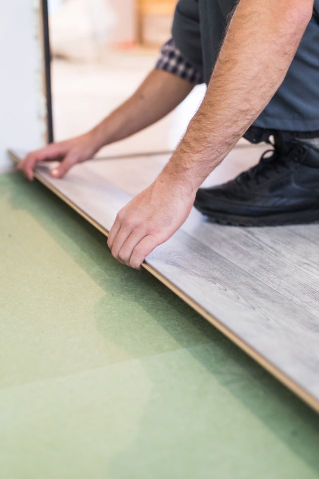 A worker adding new flooring